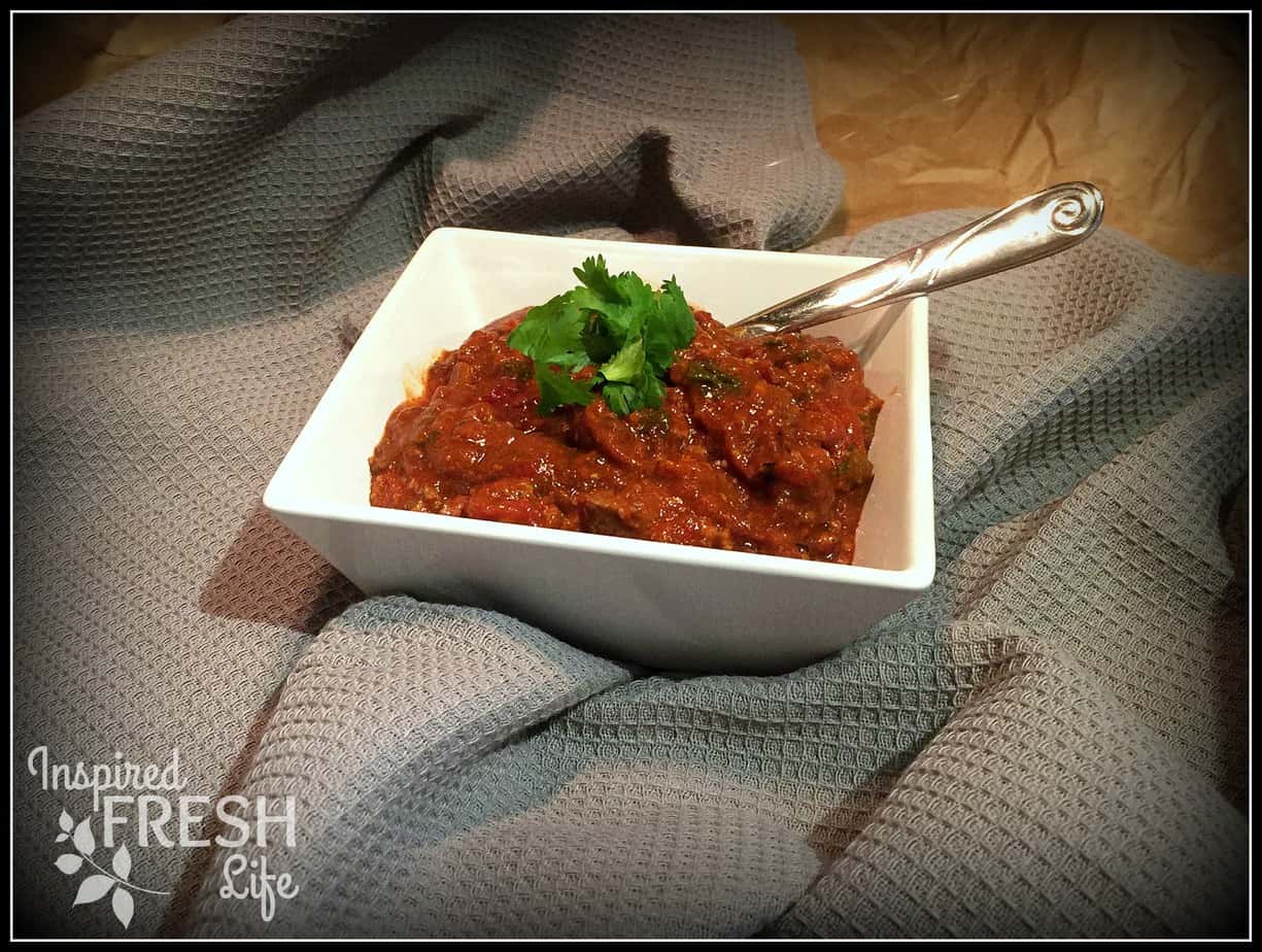 Slow Cooker Chili in a square white bowl with parsley garnish