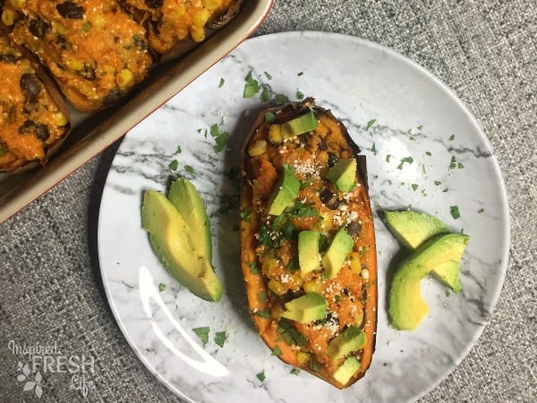 Tex-Mex Twice Baked Sweet Potatoes on a plate with avocado and cilanttro