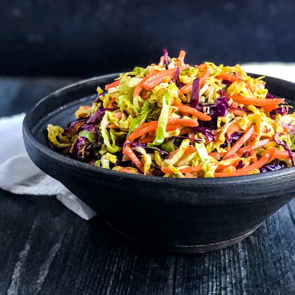 Brussels Sprouts Coleslaw in a black bowl.