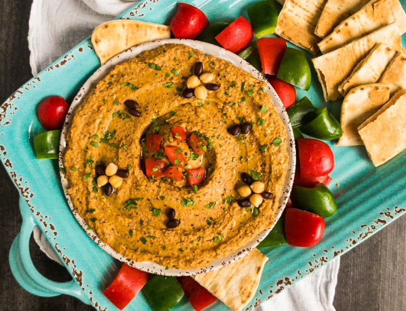 Overhead shot of Chipotle Black Bean Hummus with red and green peppers and toasted flatbread.