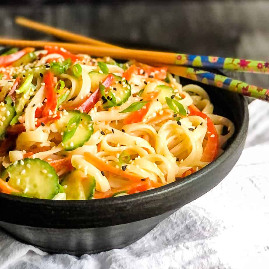 Rice Noodle Salad in a black bowl with chopsticks resting on back of bowl.