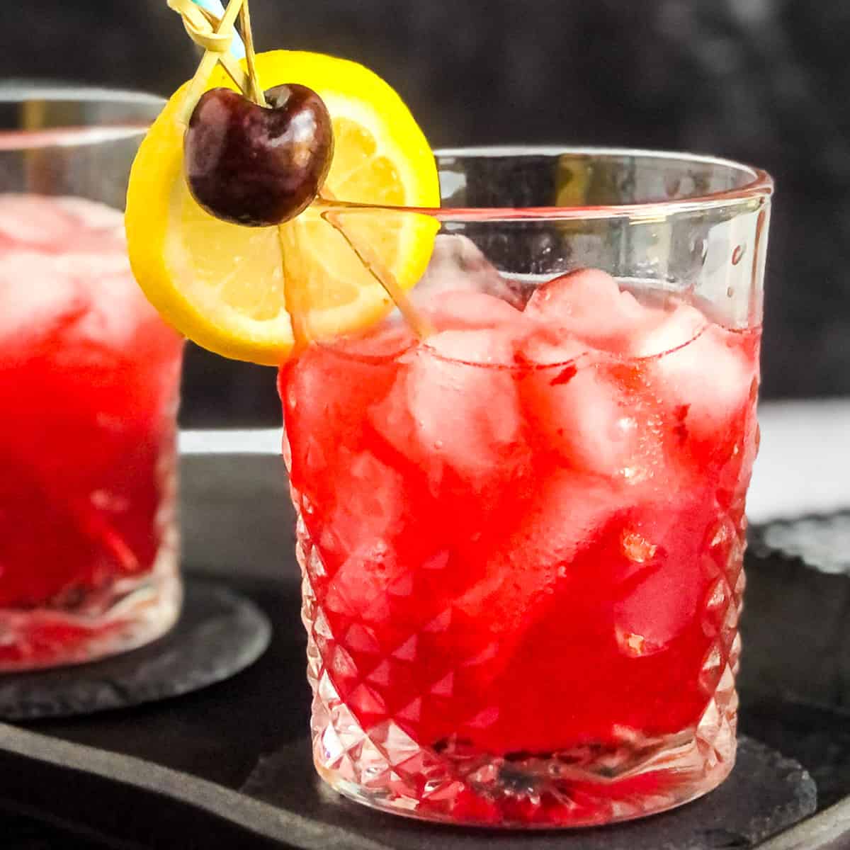 Cherry Vodka Sour garnished with a cherry and lemon wheel.