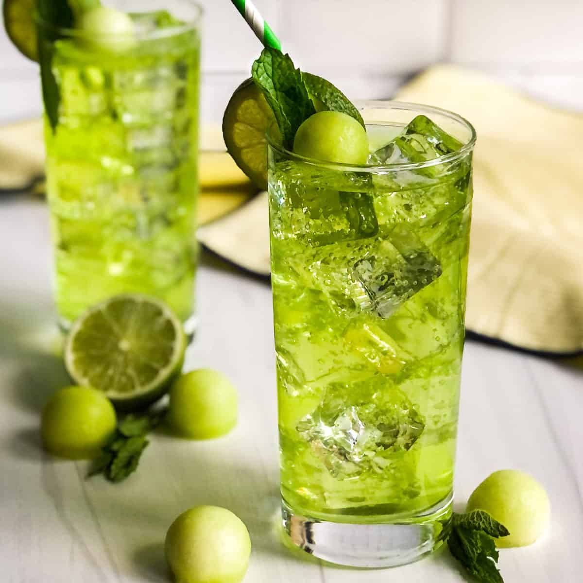 Melon mojito garnished with lime, mint and a melon ball.