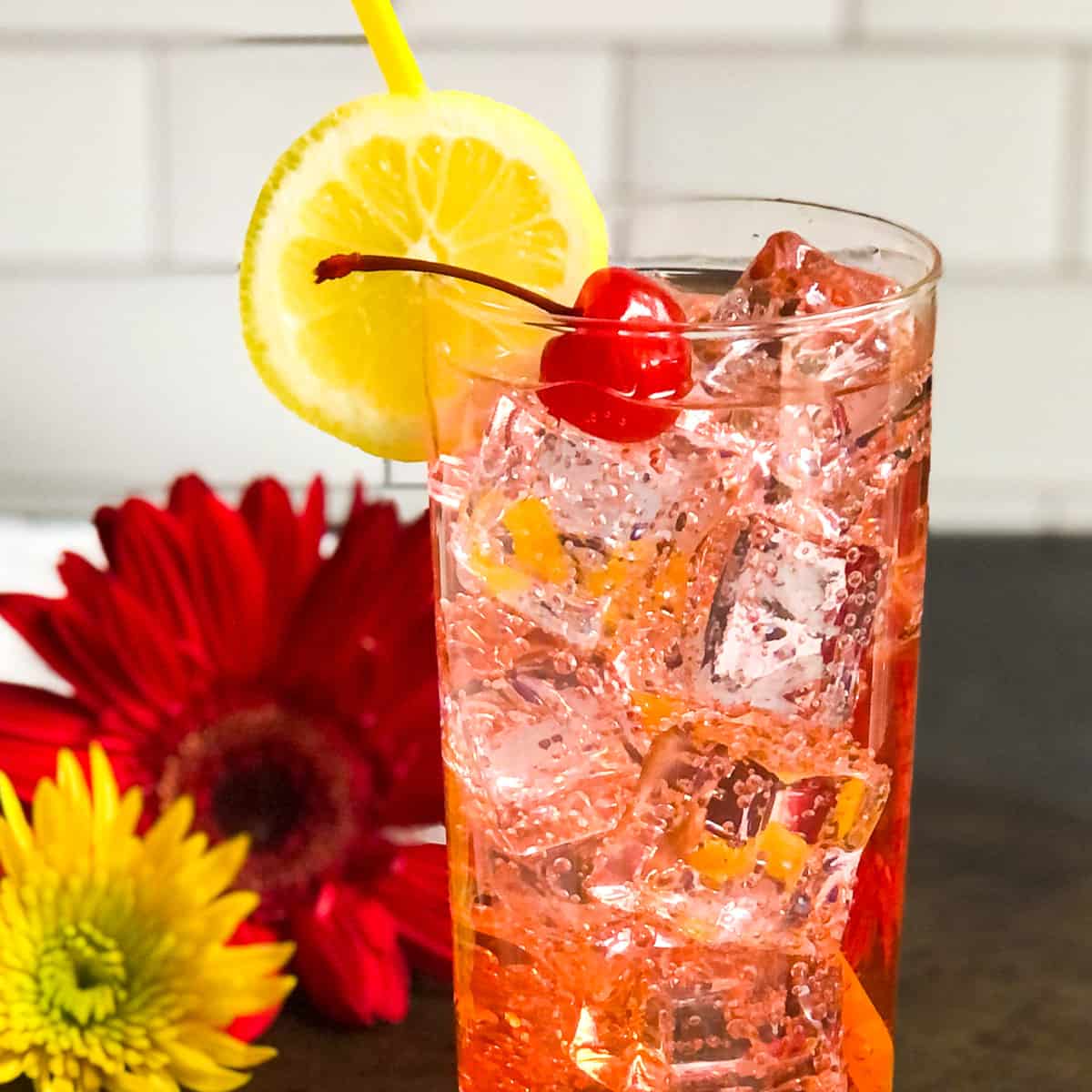 Close up of Dirty Shirley garnished with lemon wheel and cherry.