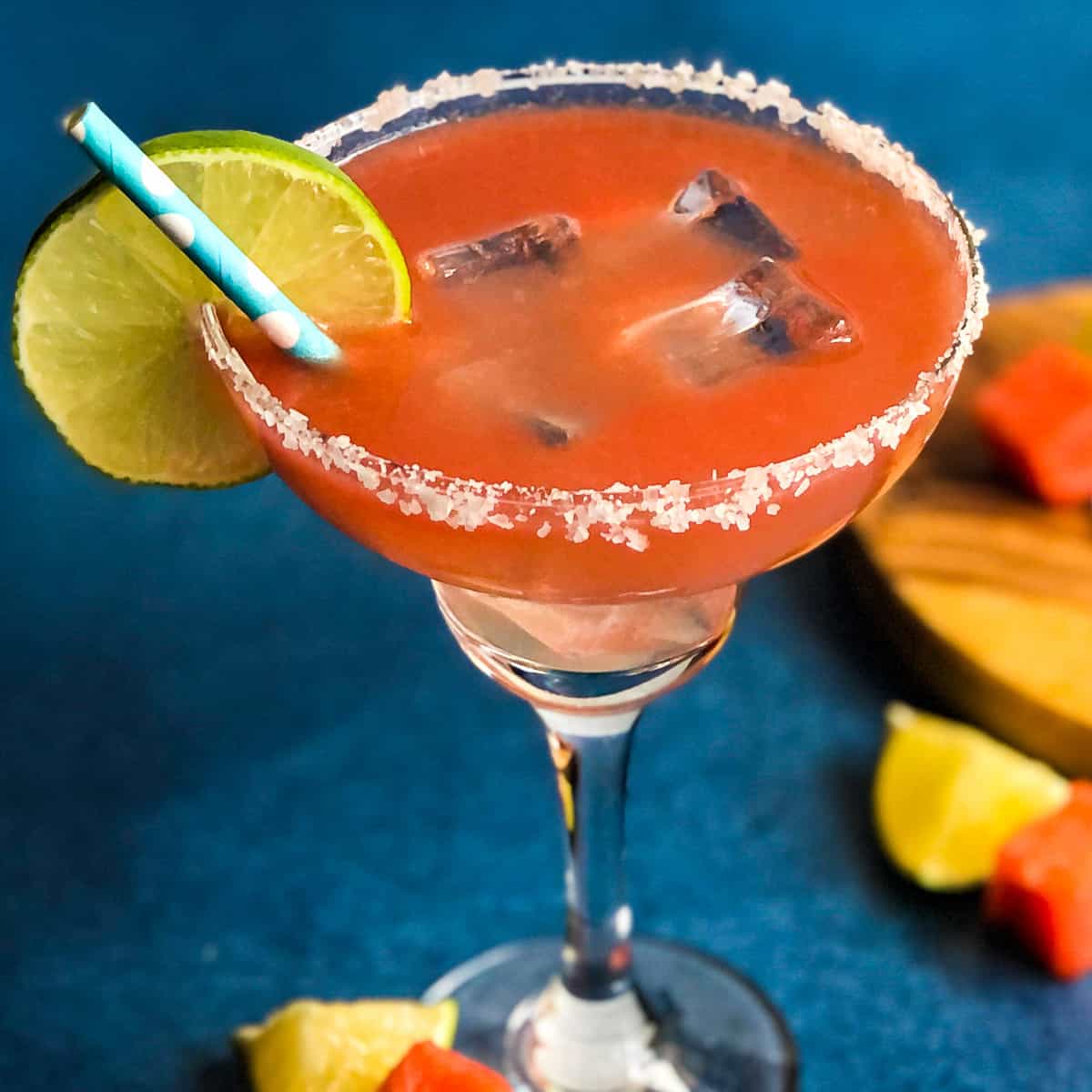 Overhead view of a watermelon margarita with a salted rim and lime wheel garnish.