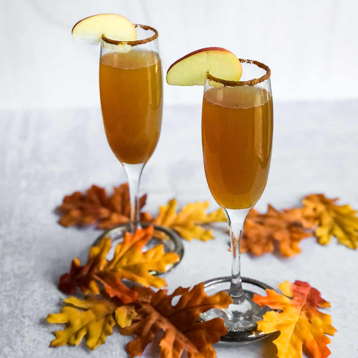 Apple Cider Mimosas surrounded by fall leaves.
