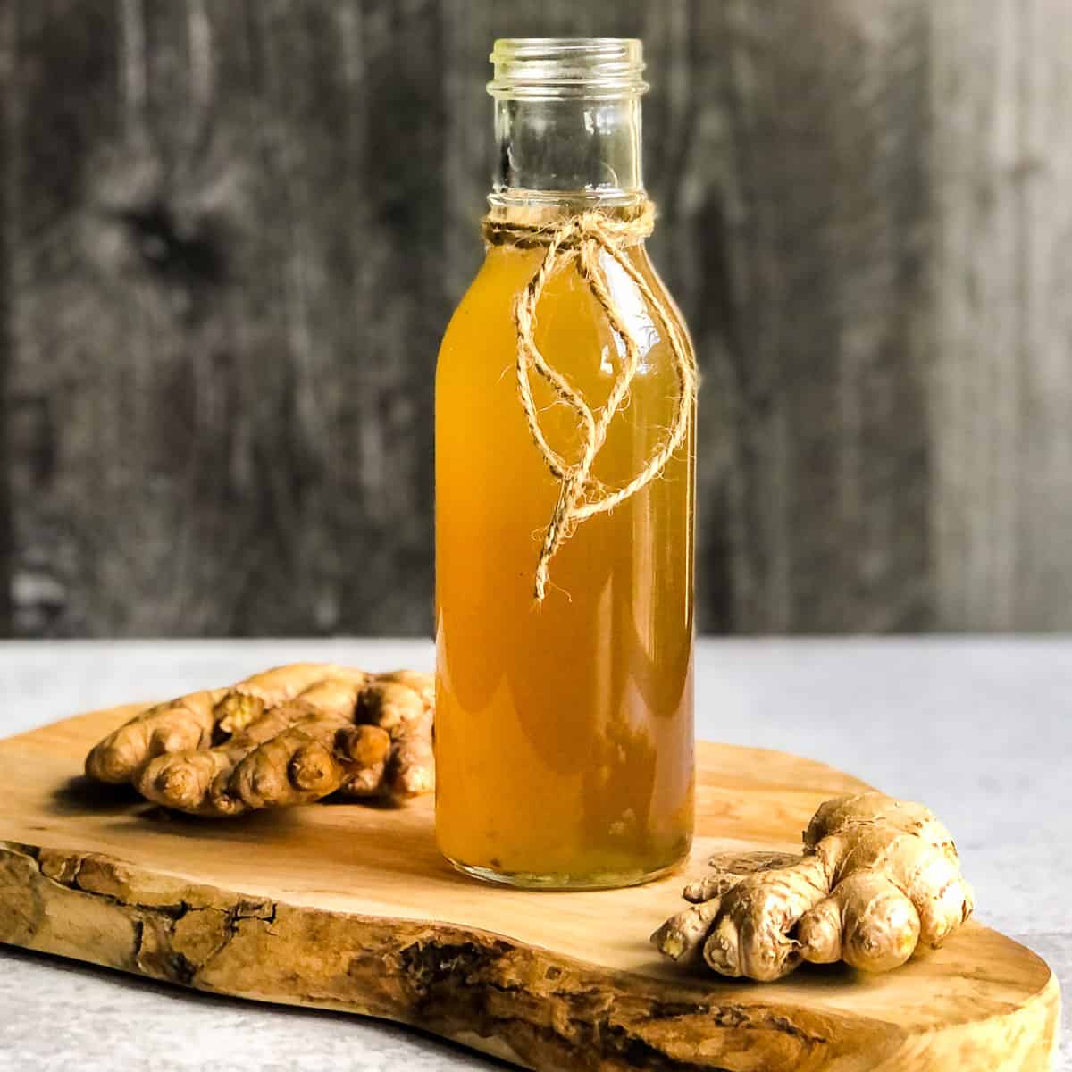 Bottle of spiced ginger syrup on a wood cutting board.